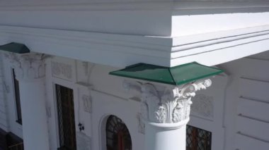 Büyük bir Ortodoks kilisesi sütunu ve özenle hazırlanmış beyaz bir yapı.