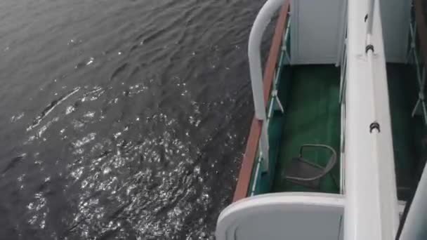 Kleine stoel staat op groen dek bij bruin witte leuningen — Stockvideo