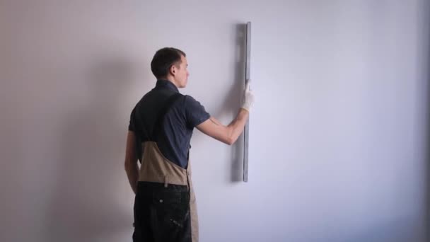 Handyman měří rovnoměrnost stěn s úrovní modrého rámu — Stock video