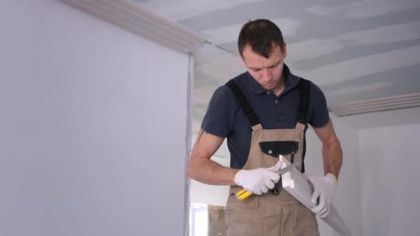 Muž stavitel brousí sádrový fretwork s užitným nožem — Stock video