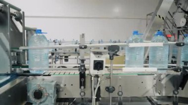 Otomatik taşıyıcıda içme suyu olan şişeler