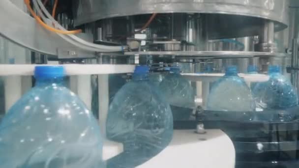 Máquina-ferramenta coloca tampas em garrafas com água na oficina — Vídeo de Stock
