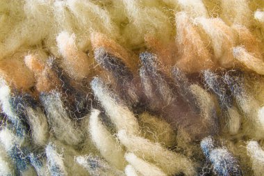 Renkli sentetik kumaşın dokusu yakından geliyor. Örtülü battaniyenin buruşuk liflerinin yakın çekimi..