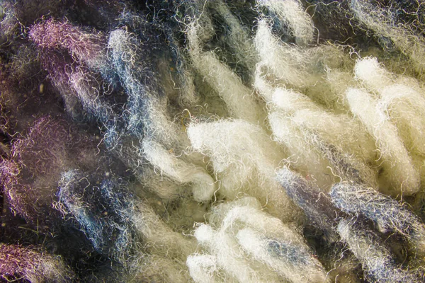Texture of colored synthetic fabric close up. Close-up of crumpled fibers of a fleece blanket.