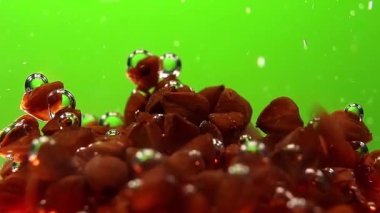 Üçgen karabuğday fındıkları yavaşça suya düşüyor ve hava kabarcıklarını yakalıyor..