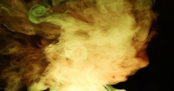 Színes füstfelhők szeszélyes mozgása sötét háttérrel szemben. — Stock videók