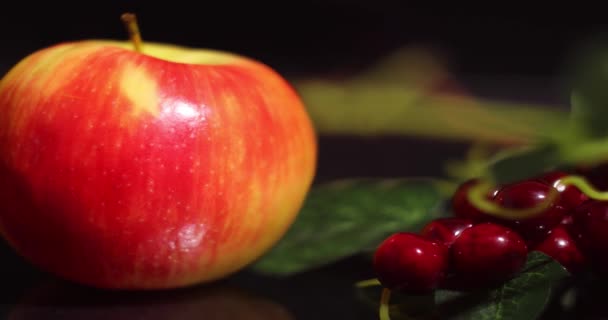 Φυσικό κόκκινο και κίτρινο μήλο στο φόντο των τεχνητών φρούτων και μούρων στο τραπέζι. — Αρχείο Βίντεο