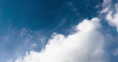 Mavi gökyüzüne karşı beyaz bulutların tuhaf dönüşümleri. Sıcak güneşli havada yaz gökyüzü.