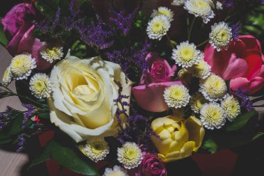 Bahar demeti kadar parlak renkli çiçekler yakın plan. Gül buketi, yeşil yapraklı laleler..