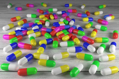 Tıbbi hazırlıkların çok renkli kapsülleri yakın plan. 3 boyutlu görüntüleme. Tahta bir masanın üzerinde ilaç kapsülleri. Gri tahtadan yapılmış bir masa..