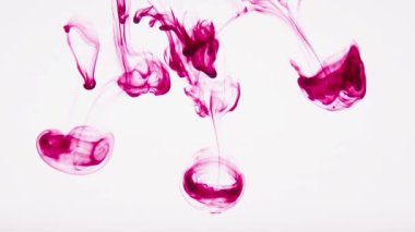 Yiyecek boyası damlaları garip bir şekilde suda bulanıklaşıyor ve yavaşça dibe batıyor. Açık arkaplanda Burgonya boyası.