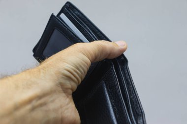 Açık arkaplanda siyah deri bir çanta var. Adamın elinde bir çanta..