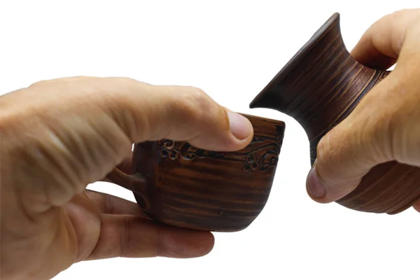 棕色陶瓷杯和壶手牵手的特写 孤立无援一个人手里拿着一只杯子和一壶烤好的粘土 背景浅 — 图库照片