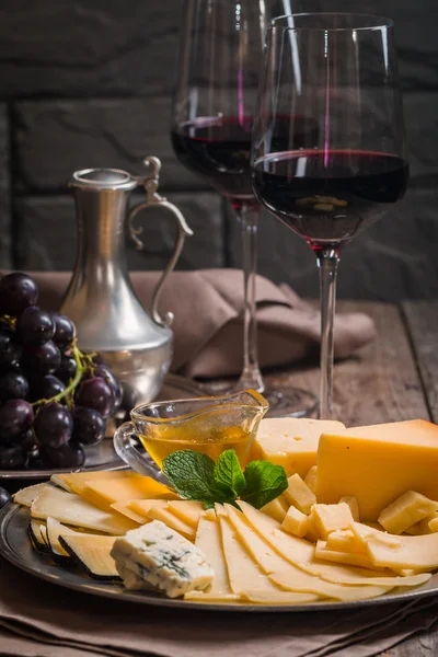 Refined still life of red wine, grapes and cheese — Stock Photo, Image