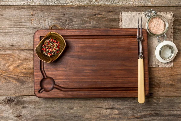 Skärbräda, kryddor och kött gaffel — Stockfoto