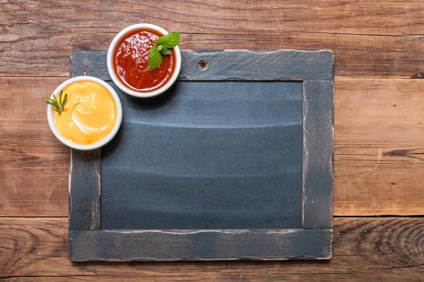 Bowls of cheese and tomato sauces  with chalk board — Stock Photo, Image