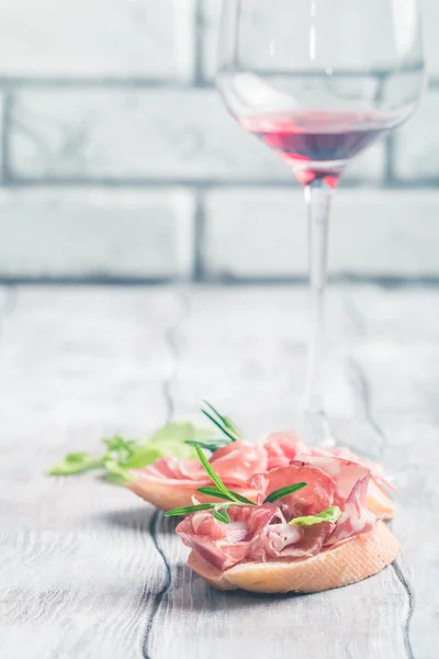 Red wine and bruschetta with prosciutto — Stock Photo, Image