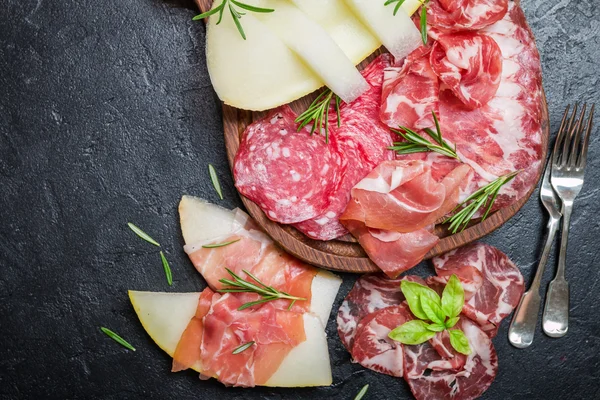 Italian ham, prosciutto and salami with melon. — Stock Photo, Image