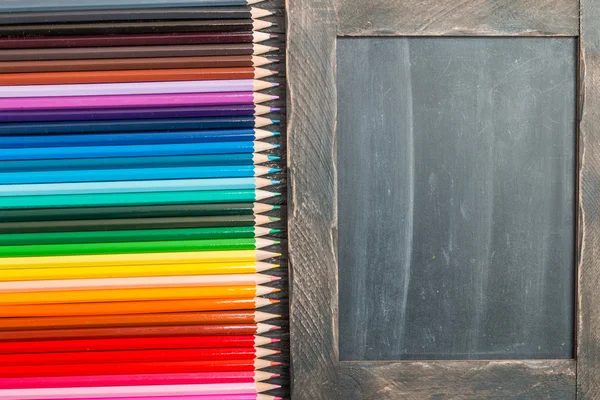 色とりどりの pensils とチョーク ボード — ストック写真