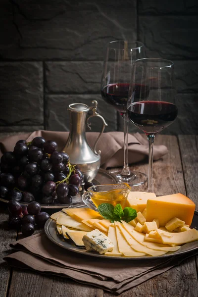 Refined still life of red wine, grapes and cheese — Stock Photo, Image