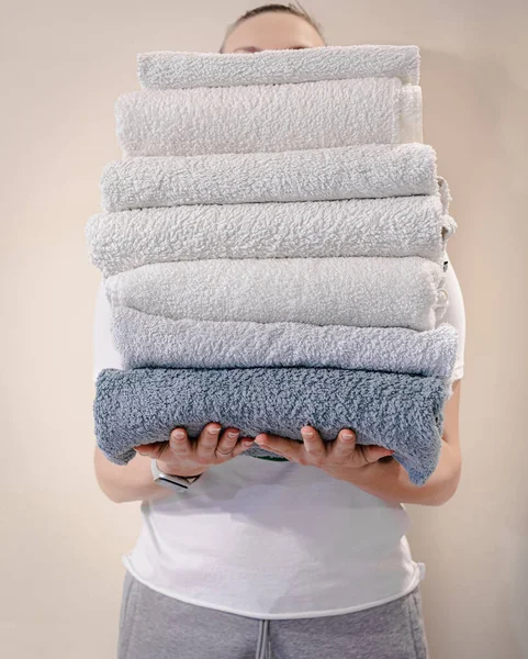 Mulher segurando uma pilha de toalhas — Fotografia de Stock