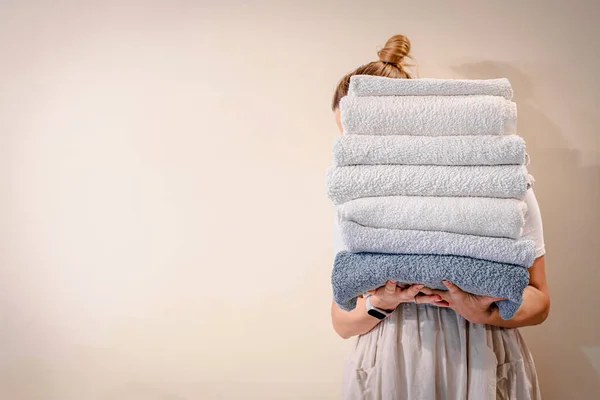 Mulher segurando uma pilha de toalhas — Fotografia de Stock