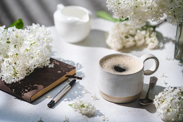 Чашка кофе и белая сирень — стоковое фото