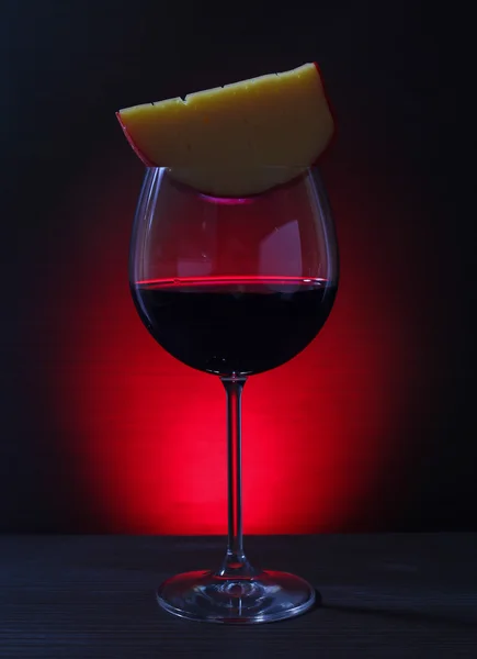 Copa de vino tinto con queso sobre fondo de luces — Foto de Stock