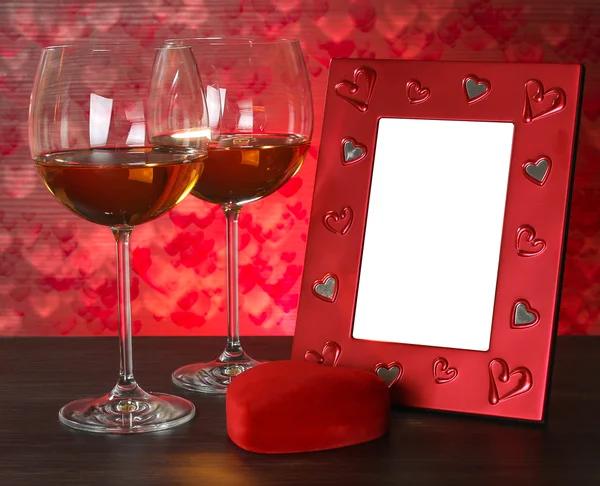İki kadeh şarap, kırmızı kalp ve fotoğraf çerçevesi. — Stok fotoğraf