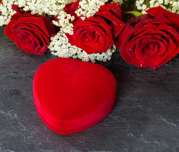 Caja de regalo en forma de corazón y ramo de rosas rojas — Foto de Stock