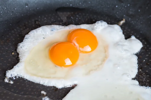 Close-up photo of two scrambled eggs in  pan — Stock Photo, Image