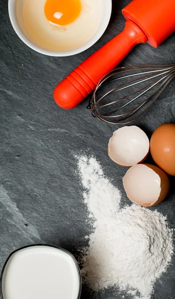 Přísady (vejce, mouku, mléko, vaječné skořápky a váleček pro pečení) — Stock fotografie