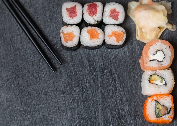 Sushi och rullar på svart ovanifrån — Stockfoto