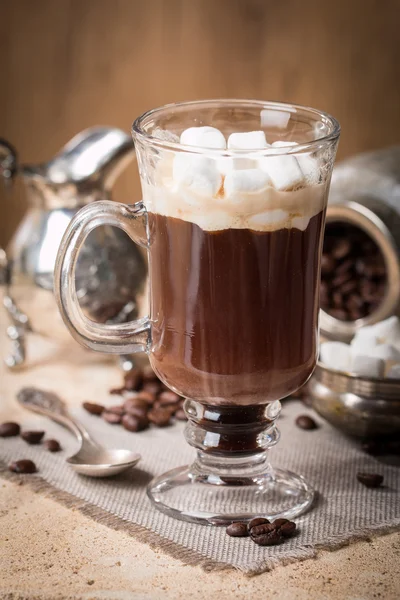 Bicchiere di caffè con marshmallow, brocca di latte e chicchi di caffè — Foto Stock