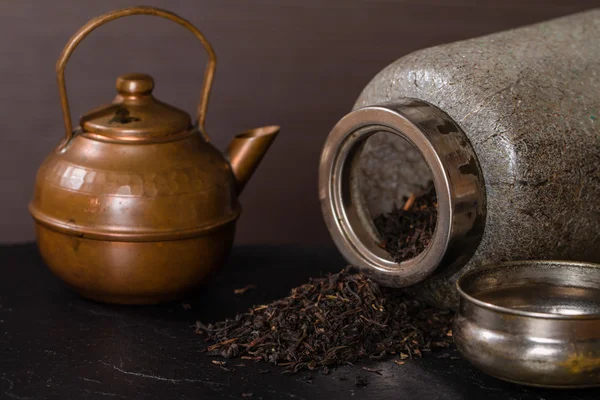 Scattered dry tea, old  jar and a vintage teapot — Stock Photo, Image