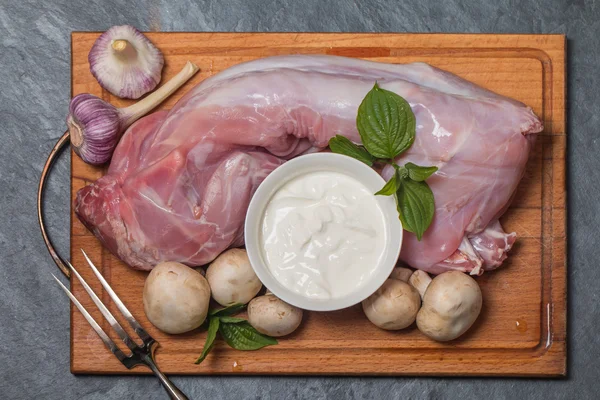 Kaninchen-Kadaver, Knoblauch, Zwiebeln, saure Sahne, Pilze und Gewürze — Stockfoto