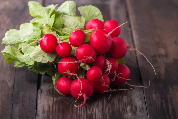 Färska rädisor på gammalt träbord — Stockfoto