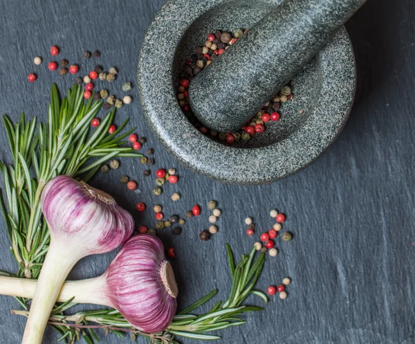 Mix of different peppers in a mortar garlic and herbs. — Stock Photo, Image