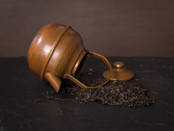 Dağınık kuru çay yaprakları ve vintage çaydanlık — Stok fotoğraf