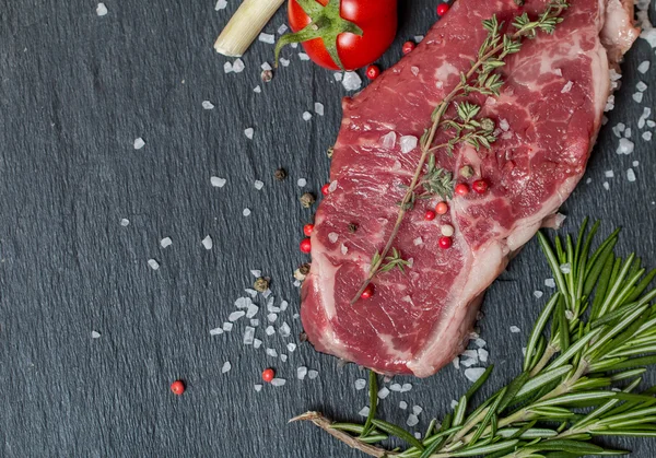 Bife de carne crua com ervas frescas e sal — Fotografia de Stock