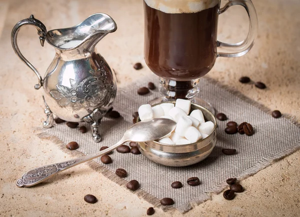 Marshmallow, mjölkkanna, sked och glas kopp kaffe — Stockfoto