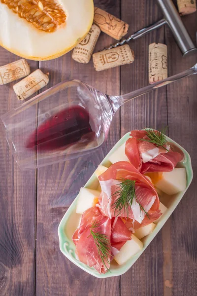 Slices of cured ham with melon and red wine — Stock Photo, Image