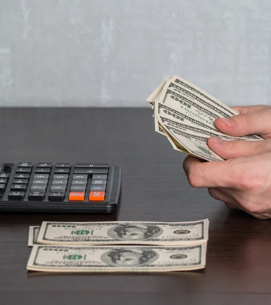 Man's hands with money and calculator — Stock Photo, Image