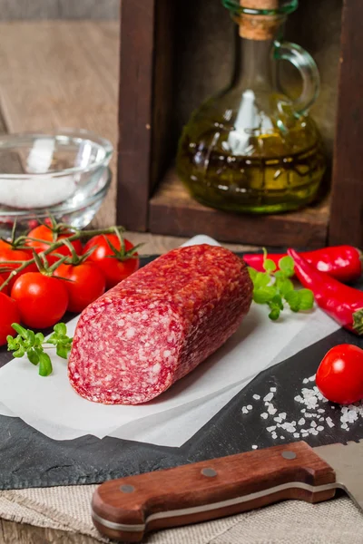 Heerlijke Salami met cherry tomaten, kruiden en olijfolie — Stockfoto