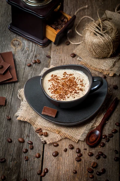 Чашка кофе с кофейными зернами и шоколадом — стоковое фото