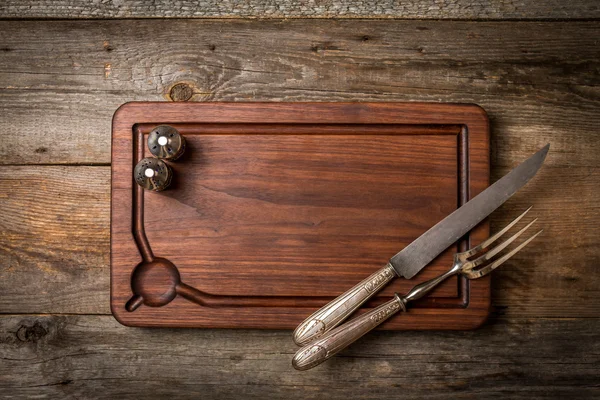 Подрібнювальна дошка, приправи та м'ясна виделка та ніж — стокове фото