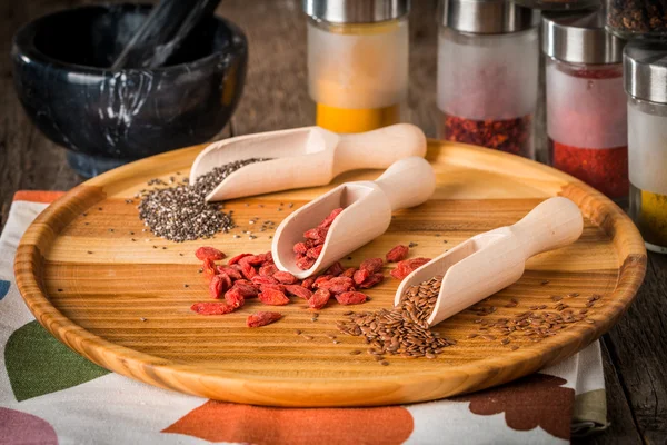 Semillas y goji en cucharas de madera — Foto de Stock