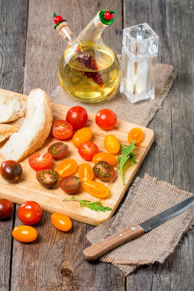 Fresh colorful tomatoes, olive oil and bread — Stock Photo, Image