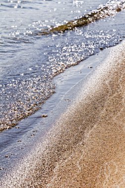 Kumlu sahilde denizin yumuşak dalgası