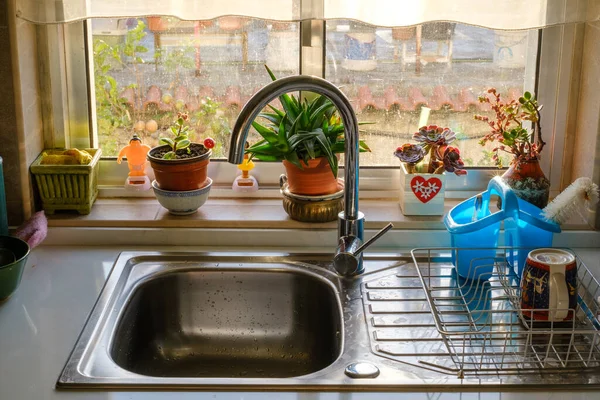 Old and awkward decoration by the sink with dirty glass windows  at grandma house